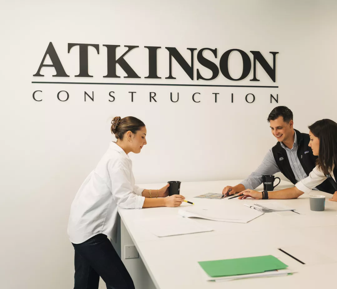 Atkinson team members gather around a table in an office meeting room