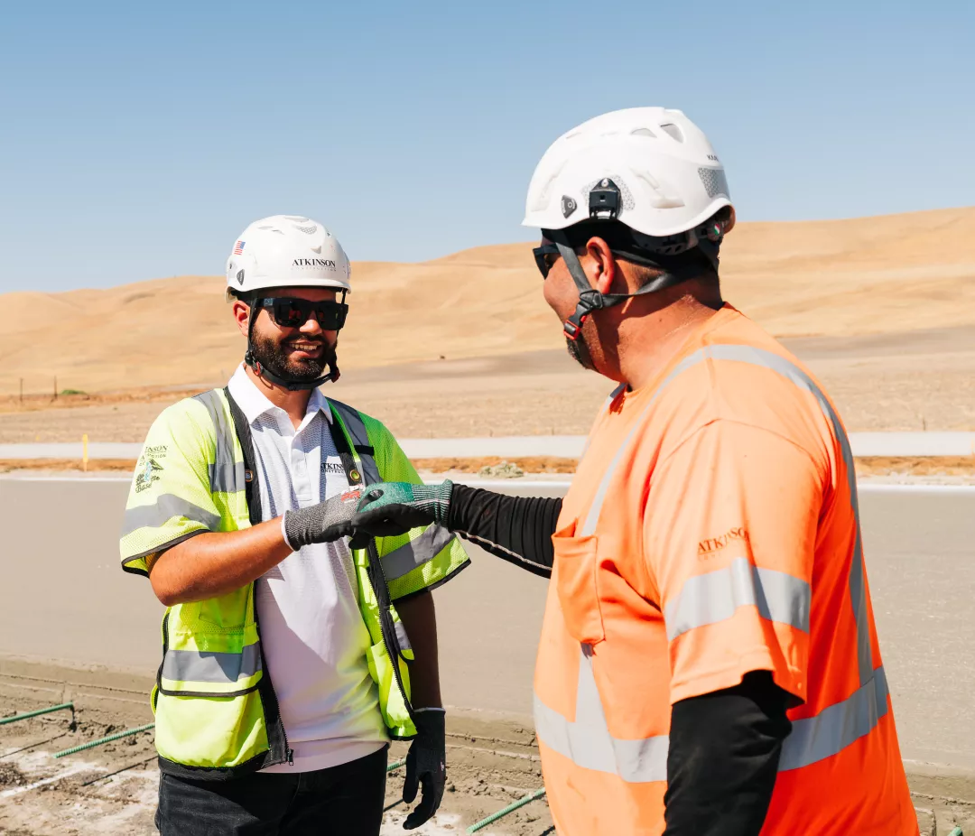Two Atkinson employees giving each other a fist bump 