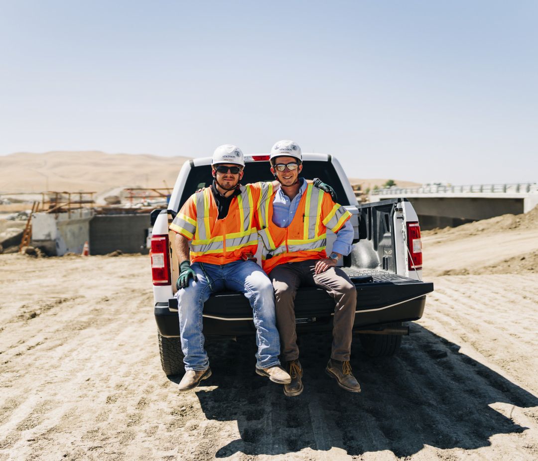 Two Atkinson teammates sit in the back of a pickup truck in California